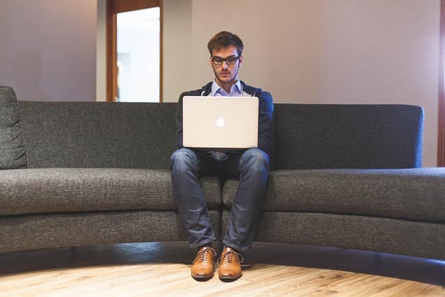 An IT engineer watching server health dashboards and alerts across multiple monitors in a network operations centre